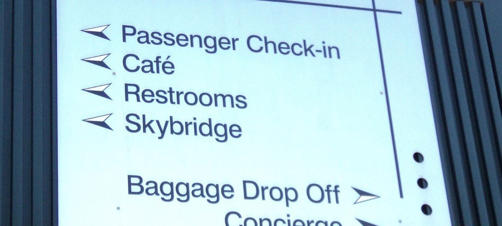 Sign for cruise ship passengers with text Passenger check-in, Cafe, Restrooms, Skybridge, Baggage Drop Off