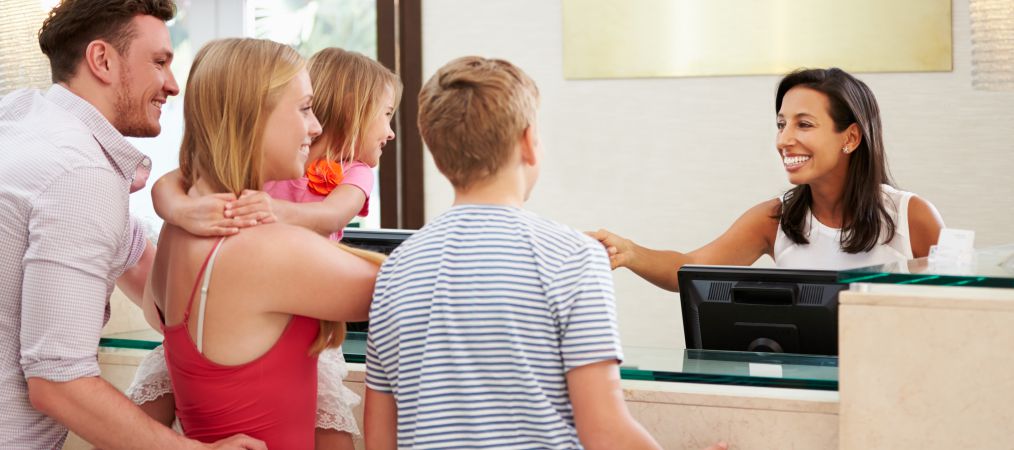 Family checking out from cruise ship front desk