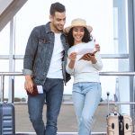 Smiling couple at airport with luggages