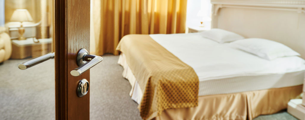 View of hotel room with large bed through open door