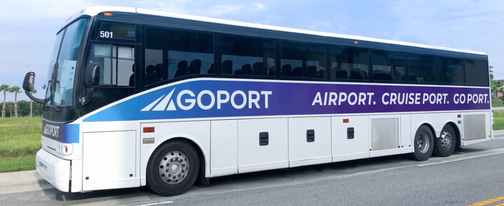 Large shuttle bus on highway between Sanford Airport and Port Canaveral with Go Port text on the side