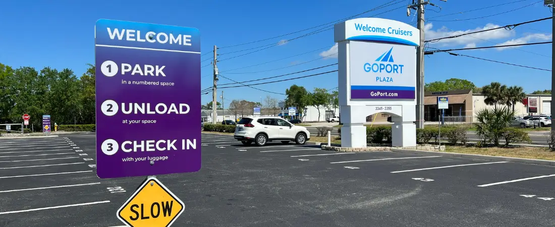 A Go Port parking lot in Port Canaveral during the day, with a shuttle bus ready to transport Carnival Mardi Gras passengers to the cruise terminal