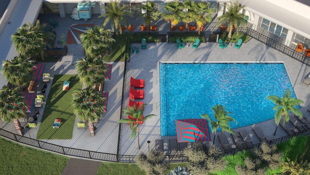 Overhead view of an outdoor pool with red deck chairs at Aloft Orlando Lake Nona hotel