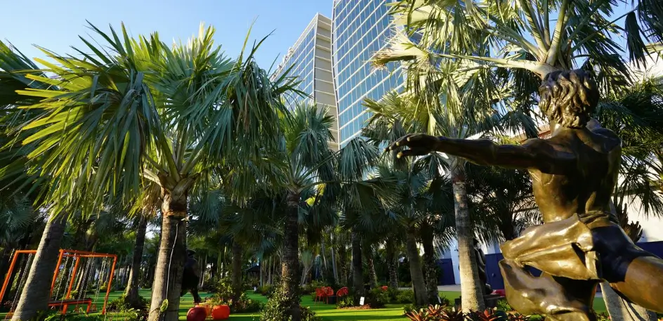 tall hotel towers behind palm trees in lake nona sculpture garden